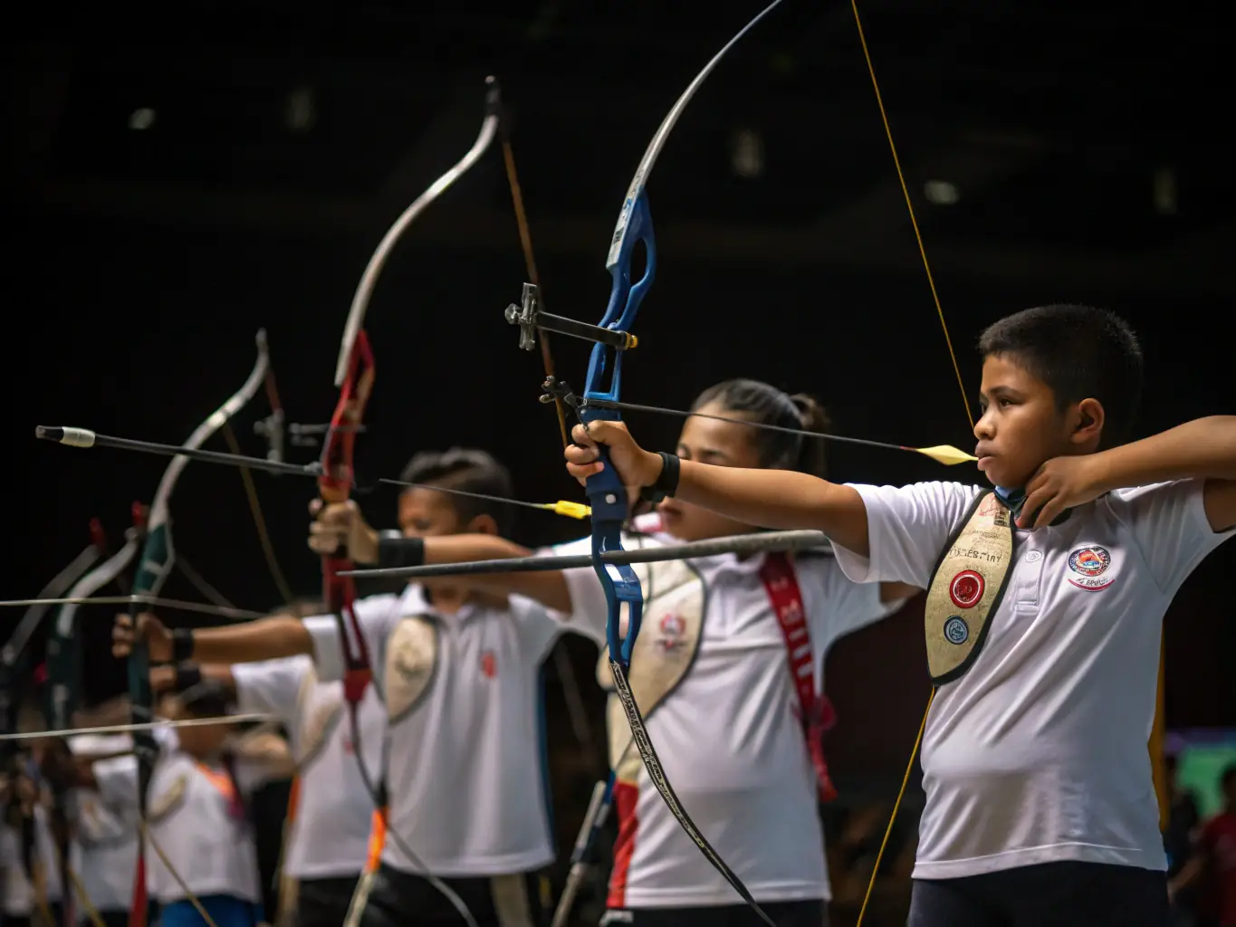 An action shot of experienced archers participating in a competitive archery event, showcasing precision and focus, with the LES ARCHERS DU CHATEAU banner visible in the background.